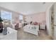 Light pink bedroom with a double bed, two windows, and a desk in front of another window at 9192 Bradleigh Dr, Winter Garden, FL 34787