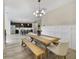 Dining area adjacent to the kitchen, featuring a wooden table, bench seating, and modern light fixture at 9192 Bradleigh Dr, Winter Garden, FL 34787