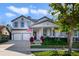 Charming two-story home with a two-car garage, covered entry, manicured lawn, and an American flag at 9192 Bradleigh Dr, Winter Garden, FL 34787