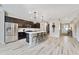 Spacious kitchen with stainless steel appliances, dark cabinets, a large center island, and wood-look floors at 9192 Bradleigh Dr, Winter Garden, FL 34787