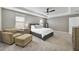 A spacious, carpeted main bedroom with a fan, two windows with blinds, and gray walls at 9192 Bradleigh Dr, Winter Garden, FL 34787