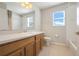 Bathroom featuring a light wood vanity, toilet, tile floor, framed mirror, and shower with curtain at 9227 Pecky Cypress Way, Orlando, FL 32836