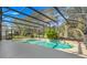 An in-ground pool inside of a screened enclosure and surrounded by mature landscaping at 9227 Pecky Cypress Way, Orlando, FL 32836