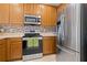 Well-lit kitchen features stainless steel appliances, a decorative tile backsplash, and wooden cabinetry at 10731 Savannah Wood Dr # 209, Orlando, FL 32832