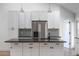 Modern kitchen with stainless steel refrigerator, white cabinets, large center island, and stylish backsplash at 12401 Harney Dr, Orlando, FL 32828