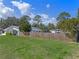 Expansive backyard featuring a wooden fence, lush lawn, and mature trees at 1300 Conrad Dr, New Smyrna Beach, FL 32168
