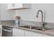Close-up of the kitchen featuring granite countertops, stainless appliances, and modern faucet at 1300 Conrad Dr, New Smyrna Beach, FL 32168