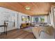 Cozy sunroom with wood ceilings, a sectional sofa, and a wall-mounted television at 1300 Conrad Dr, New Smyrna Beach, FL 32168