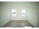 Bright bedroom with light-colored wood flooring, white walls, and natural light from two windows at 15215 Sw 43Rd Ct, Ocala, FL 34473