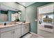 A bathroom showcasing a double vanity, large mirror, granite countertop, and connection to a bedroom at 1705 Three Bars Rd, Kissimmee, FL 34744