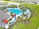 Aerial view of community pool with palm trees, lounge chairs, umbrellas, and covered areas at 1706 Three Bars Rd, Kissimmee, FL 34744