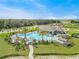 Aerial view of resort-style community pool with palm trees, lounge chairs, and a pavilion at 1718 Three Bars Rd, Kissimmee, FL 34744