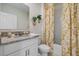 Elegant bathroom with granite countertop, white cabinets, and a decorative shower curtain at 1730 Three Bars Rd, Kissimmee, FL 34744