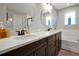 A beautifully renovated bathroom boasting a double vanity, soaking tub, and tiled walls at 1832 Farnham Dr, Ocoee, FL 34761