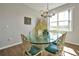 Sunlit dining area features a glass table, unique chairs and a modern chandelier at 1832 Farnham Dr, Ocoee, FL 34761