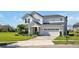 Charming two-story home with a well-manicured lawn, brick driveway, and attached two-car garage at 1832 Farnham Dr, Ocoee, FL 34761