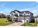 Beautiful two-story home showcasing a manicured lawn, brick driveway, and a charming covered front porch at 1832 Farnham Dr, Ocoee, FL 34761