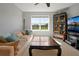 A cozy living room with a tan couch, large window, and stylish cabinet at 1832 Farnham Dr, Ocoee, FL 34761