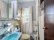 Quaint bathroom with light blue and white tiles, a window, and white curtain at 200 Dr Martin Luther King Jr Se St, Fort Meade, FL 33841