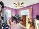 Bedroom featuring purple walls and pink carpet with a ceiling fan, and two windows at 200 Dr Martin Luther King Jr Se St, Fort Meade, FL 33841