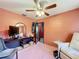 Bedroom featuring pink walls and pink carpet with a ceiling fan, and a black desk at 200 Dr Martin Luther King Jr Se St, Fort Meade, FL 33841