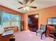 Bedroom featuring pink walls and pink carpet with a ceiling fan, a window, and a wooden dresser at 200 Dr Martin Luther King Jr Se St, Fort Meade, FL 33841