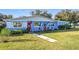 Inviting single-story home featuring a colorful exterior, red doors, and a lush green lawn at 200 Dr Martin Luther King Jr Se St, Fort Meade, FL 33841