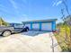 Three-car garage offers ample parking space, along with a blue exterior that matches the main house at 200 Dr Martin Luther King Jr Se St, Fort Meade, FL 33841
