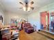 Cozy living room with wood paneled walls, ceiling fan, and view into additional space at 200 Dr Martin Luther King Jr Se St, Fort Meade, FL 33841