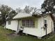 Exterior view of the home, showcasing the front door and window air conditioning units at 2219 W Pine St, Orlando, FL 32805