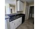Well-lit kitchen with stainless steel sink, black appliances, white cabinets, and black granite counters at 2516 Grassy Point Dr # 206, Lake Mary, FL 32746