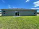 Home backyard featuring a well-maintained lawn and a sliding glass door for indoor-outdoor living at 2549 Sw 175Th Loop, Ocala, FL 34473