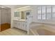 Bathroom featuring dual sinks, a built-in bathtub, and tiled floors at 26913 Forest Hills St, Leesburg, FL 34748