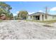 Wide view of the backyard showing the gravel, fence, small trees, and house at 281 Luis Ln, Debary, FL 32713