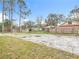 Gravel backyard with new trees and wood fence in the distance at 281 Luis Ln, Debary, FL 32713