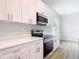 Modern kitchen features stainless steel appliances and white countertops and cabinetry at 281 Luis Ln, Debary, FL 32713