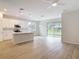 Bright, open kitchen with white cabinets, stainless steel appliances, and wood-look flooring at 281 Luis Ln, Debary, FL 32713