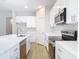 Bright kitchen features white cabinets, stainless steel appliances, and quartz countertops at 281 Luis Ln, Debary, FL 32713