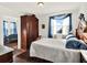 Bright bedroom features a large bed, a vintage armoire, and a window view at 340 W 9Th Ave, Mount Dora, FL 32757
