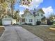 Charming light-green two-story home with a well-maintained lawn, a detached garage, and a long concrete driveway at 340 W 9Th Ave, Mount Dora, FL 32757