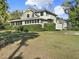 Spacious two-story home showcasing an expansive lawn, covered porch, balcony, and well-maintained landscaping at 340 W 9Th Ave, Mount Dora, FL 32757