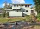 View of the rear of this two-story home with its upper balcony, screened porch, and grassy lot at 340 W 9Th Ave, Mount Dora, FL 32757
