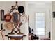 Foyer features a decorative hall tree, and a view into a bright room with lace curtained window at 340 W 9Th Ave, Mount Dora, FL 32757