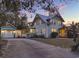Inviting two-story home with lush landscaping, front gate and a detached garage at dusk at 340 W 9Th Ave, Mount Dora, FL 32757