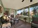 This sunroom features olive-green walls, wood flooring and ample windows, and a comfortable seating arrangement at 340 W 9Th Ave, Mount Dora, FL 32757