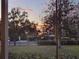 Outdoor view of a landscape featuring mature trees and glimpses of a beautiful sunset at 340 W 9Th Ave, Mount Dora, FL 32757