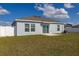 View of the backyard with a freshly manicured lawn, a charming patio, and a well-maintained privacy fence at 350 Rustic Rail Dr, Lake Wales, FL 33859