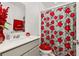 Bathroom with a vanity, sink, mirror, toilet, and decorative flower-patterned shower curtain and matching seat cover at 350 Rustic Rail Dr, Lake Wales, FL 33859