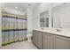 Bathroom features double sinks, large mirrors, and decorative shower curtain at 350 Rustic Rail Dr, Lake Wales, FL 33859