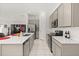 Modern kitchen featuring stainless steel appliances, a large island with quartz countertops, and gray cabinetry at 350 Rustic Rail Dr, Lake Wales, FL 33859